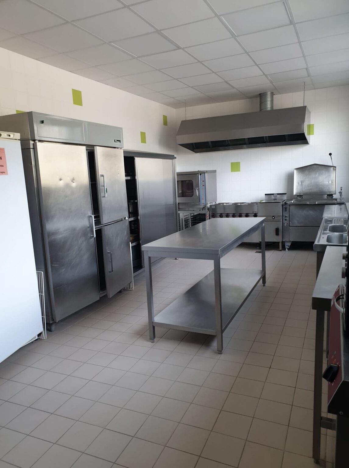 Ci-dessous, une cuisine industrielle entièrement équipée remise aux normes actuelles et la salle séparée dédiée à la plonge.