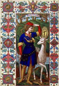Enluminure intitulée « Hubertus » : un jeune homme en tunique bleue et bonnet rouge fait face à un cerf blanc portant une croix lumineuse entre ses bois, dans une forêt, au milieu d'un encadrement peint.