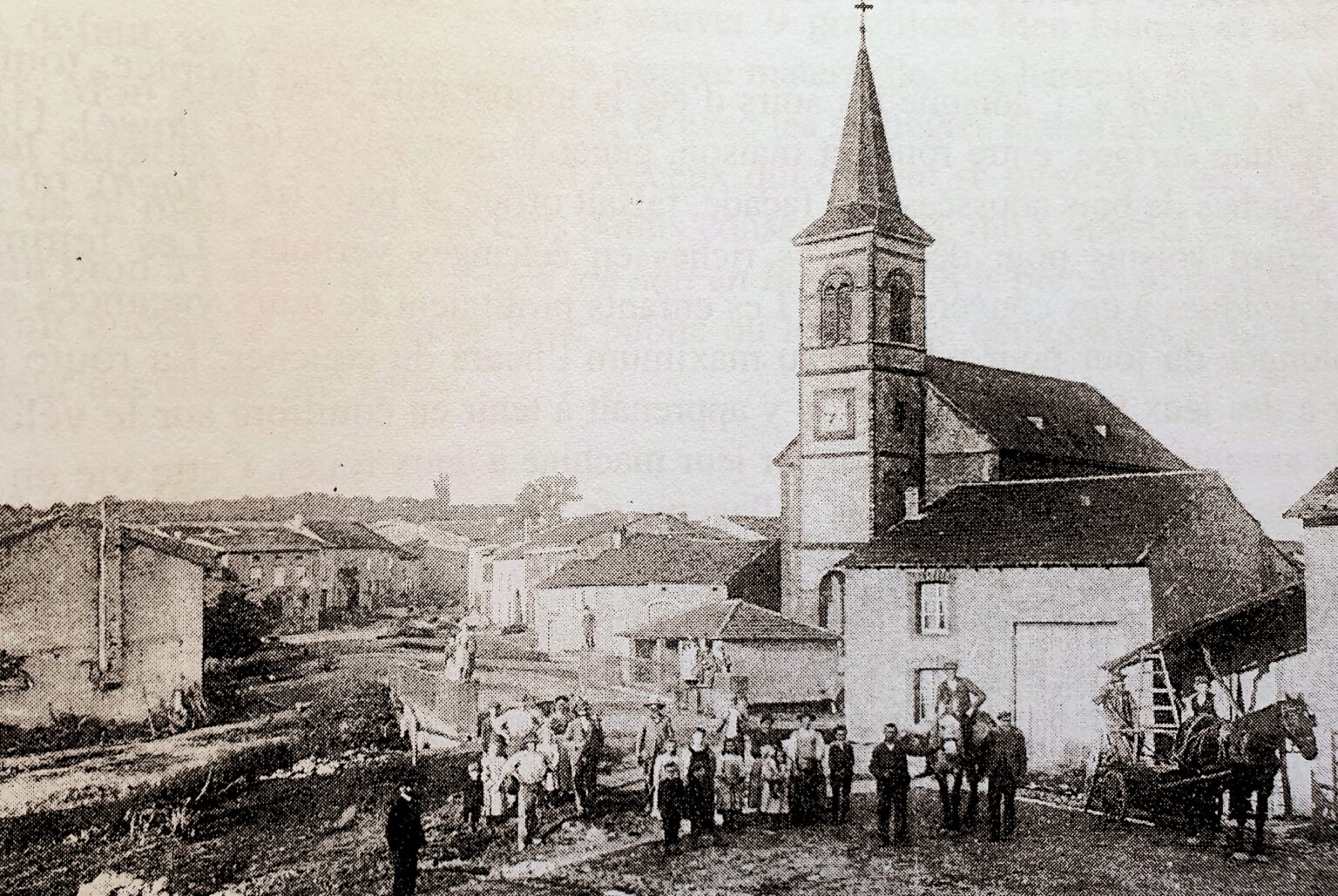 Vue ancienne du village : l'église et son clocher pointu dominent une rue en pente bordée de maisons basses ; au premier plan, sur la terre battue, un groupe de villageois, des enfants et deux chevaux attelés.