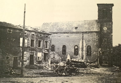 L'église après la guerre : la tour du clocher est réduite à un moignon sans flèche, le mur de la nef est marqué d'impacts et la maison voisine est éventrée ; une charrette attelée stationne sur la place.